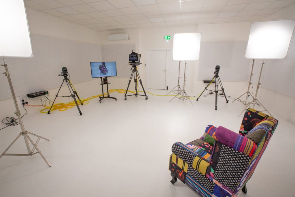 Empty white video studio with cameras and lights